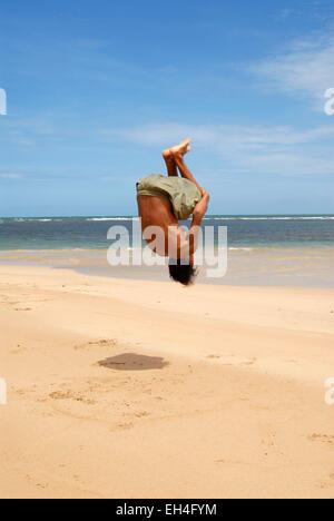 Brasilien, Bahia Zustand, Guarajuba, junger Mann ausführen ein Back flip am Strand Stockfoto