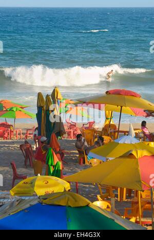 Brasilien, Bahia state, Salvador de Bahia, die Strände im Süden der Stadt, Surfer auf einer Welle und am Strand unter Sonnenschirmen gruppieren Stockfoto