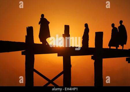 U Bein, Silhouette der Mönche auf der U Bein Brücke bei Sonnenuntergang, Amarapura, Mandalay, Myanmar Stockfoto