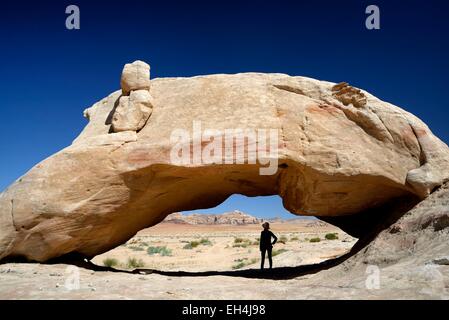 Jordan, Wüste Wadi Rum, Schutzgebiet Weltkulturerbe der UNESCO, Silhouette einer Frau im Schatten der natürlichen Felsbogen Stockfoto