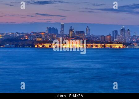 Türkei, Istanbul, Besiktas Bezirk, Dolmabahce Palast (Dolmabahce Sarayi), Nachtansicht von einem beleuchteten Palast vor einem modernen städtischen Bereich am Meer Stockfoto