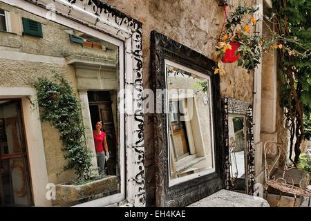 Frankreich, Alpes Maritimes, Valbonne, Reflexion in einem Spiegel vor einer antiken Darlegung ihrer Objekte auf der Straße Stockfoto