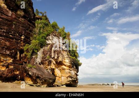 Bako Nationalpark, Frau zu Fuß am Strand von Telok Assam, Sarawak, Malaysia, Borneo, in der Nähe von einer Klippe und Felsen Stockfoto