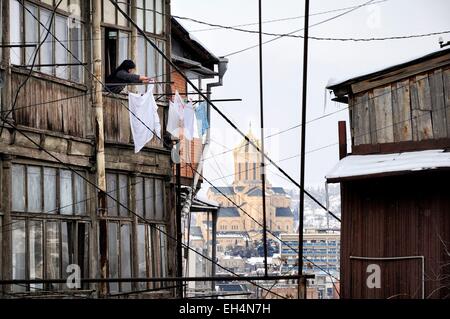 Georgien, Kaukasus, Tiflis, Straße der Altstadt mit einer Frau am Fenster ihres Hauses, viele Kabel und Rohre, Holy Trinity Cathedral von Tiflis im Hintergrund Stockfoto