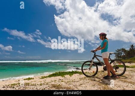 Mauritius, Südwestküste, Black River District, Frau am Strand Radfahren Stockfoto