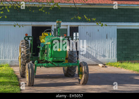 Vintage John Deere Traktor vor einer alten Scheune. Stockfoto