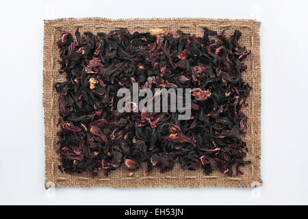 Rahmen aus Sackleinen und Hibiskus, liegend auf einem weißen Hintergrund Stockfoto