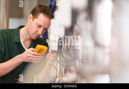 Leitender Techniker reparieren Landmaschinen in einem Gewächshaus Stockfoto