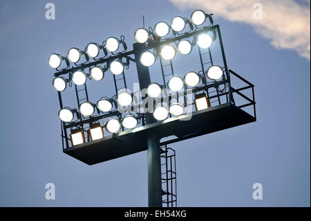 Fußball-Stadion-Scheinwerfer eingeschaltet bei Sonnenuntergang Stockfoto