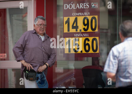 Mexico City, Mexiko. 6. März 2015. Ein Mann geht vor einer Bank-Filiale, wo ist der Wechselkurs des mexikanischen Peso gegenüber dem US-Dollar, in Mexiko-Stadt, Hauptstadt von Mexiko, am 6. März 2015 gezeigt. © Pedro Mera/Xinhua/Alamy Live-Nachrichten Stockfoto