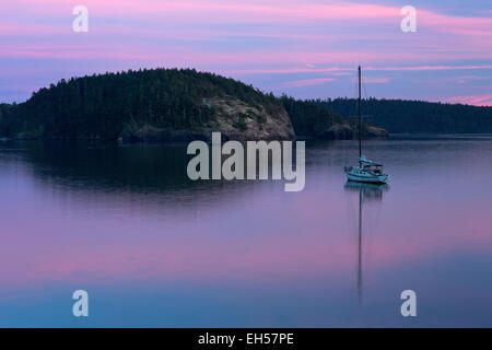 Ein Segelboot ist sicher im Hafen von Bowman Bay auf Whidbey Island bei Sonnenuntergang. Stockfoto