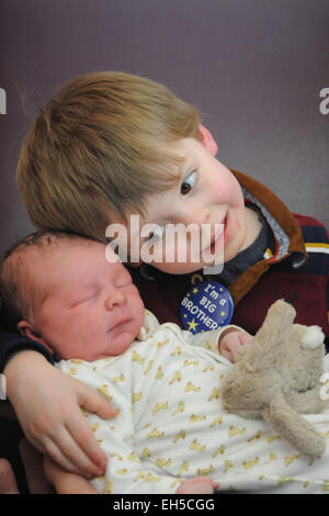 Ein großer Bruder trifft seinen Neugeborenen kleinen Baby Bruder zum ersten Mal im Krankenhaus Stockfoto