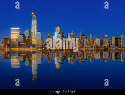 Lower Manhattan Skyline bei Nacht spiegelt sich im Wasser Stockfoto