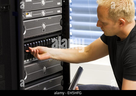 IT-Techniker / Berater arbeiten in einem Rechenzentrum. Dieses Gehäuse ist ein SAN (Speichernetzwerk) und Servern an der Spitze. Stockfoto