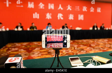 (150307)--Peking, 7. März 2015 (Xinhua)--ein Journalist nutzt ein Handy und ein Mini-Stativ schießen Videos während einer eine Podiumsdiskussion der Abgeordnetenkammer zu Chinas 12. nationalen Volksarmee Kongress (NPC) aus der ostchinesischen Provinz Shandong in Peking, Hauptstadt von China, 7. März 2015. (Xinhua/Wang Jianhua) (Yxb) Stockfoto