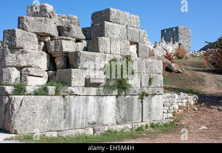 Ruinen der Mauer des alten Messini, mit einem Wachturm im Hintergrund, neben dem Arcadia-Tor. Stockfoto