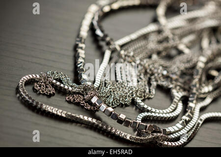 Haufen von sortierten Silberketten mit glänzende Box Ketten, Cube-Ketten und gewöhnlichen verknüpften Kette auf einem grauen Hintergrund konzeptionelle von Modeschmuck Stockfoto