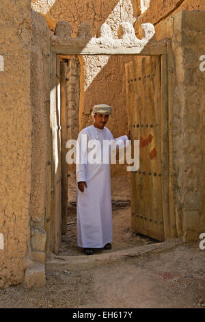 Mann in der Tür des alten Lehmziegeln bauen, Al-Hamra, Oman Stockfoto