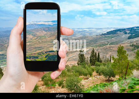 Konzept - Touristen nehmen Foto gelobte Land vom Berg Nebo in Jordanien auf mobile Gadget zu reisen Stockfoto