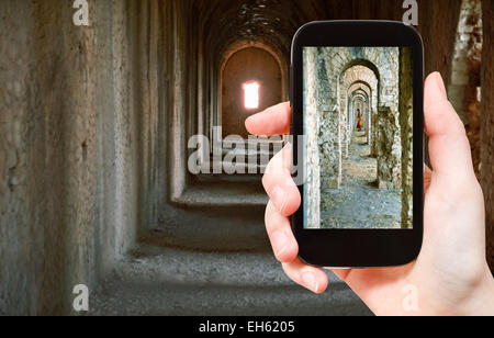 Konzept - touristische Aufnahme der alten Arkaden im Tempel des Jupiter Anxur (Jugend) in Terracina Stadt auf mobile Gadget zu reisen, Stockfoto