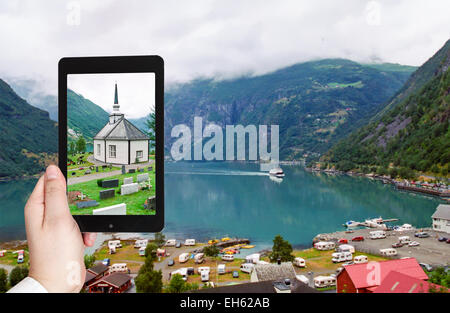 Konzept - Touristen nehmen Foto von Geiranger Dorf am Strand der Geirangerfjord Fjord in Norwegen auf mobile Gadget zu reisen Stockfoto