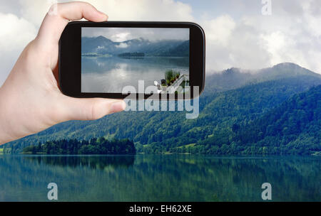 Reisen Sie Konzept - Touristen nehmen Foto von Schliersee See in bayerischen Alpen auf mobile Gadget, Deutschland Stockfoto