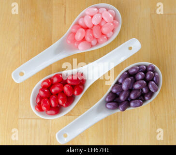 Pink, rot und lila jellybeans in weißer Keramik Löffel Stockfoto