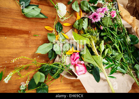 Frische Blumen auf Holztisch. Blumengeschäft am Arbeitsplatz. Stockfoto