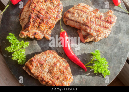 Elch Steak, rote Chili und grüner Petersilie, auf einer Steinplatte Stockfoto