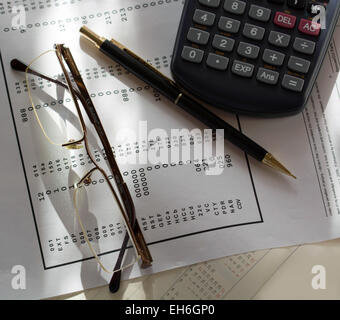 Business-Rechner, Gläser und Stift auf Finanzdokumente Stockfoto