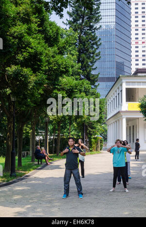 Menschen Sie praktizieren Tai Chi in einer kleinen Gruppe, Hong Kong Park, Hong Kong Stockfoto