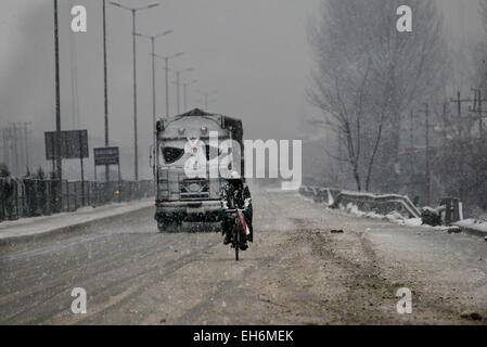 Srinagar, Kaschmir Indien kontrollierten. 8. März 2015. Ein Kashmiri Mann fährt Fahrrad am Stadtrand von Srinagar, Sommer in der Hauptstadt von Indien kontrollierten Kaschmir, 8. März 2015. Kaschmir Indien kontrollierten erhielt starkem Regen und Schneefall am Sonntag, zwingt die Schließung von Jammu-Srinagar Bundesstraße, die einzige Verbindungsstraße Region Kaschmir Indien. © Javed Dar/Xinhua/Alamy Live-Nachrichten Stockfoto