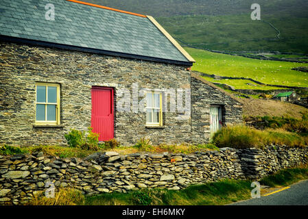 Steinhaus und Schafe auf der Weide mit Steinmauern am Slea Head Drive. Dingle Halbinsel, Irland. Stockfoto