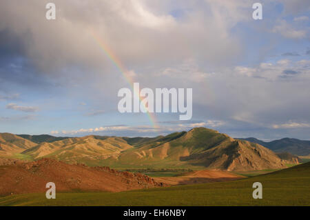 Fahren südlich in Richtung Jargalant, Regenbogen über Berge im grünen Wiesen Stockfoto
