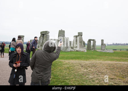 Touristen fotografieren mit Telefon er Monument Stonehenge, England Stockfoto