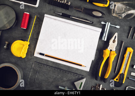 Sortierte tun es selbst Heimwerkerwerkzeuge und leere Seite Notebook als Copy Space für Home Verbesserung Projektplanung oder irgendwelche andere Werke Stockfoto