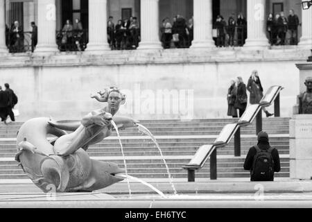 Teil des Trafalgar Square, London, England - eine Wasserskulptur in einer der Brunnen und der Nationalgalerie im Hintergrund Stockfoto