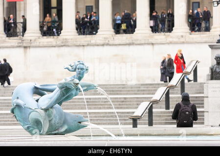 Teil des Trafalgar Square, London, England - eine Wasserskulptur in einer der Brunnen und der Nationalgalerie im Hintergrund Stockfoto