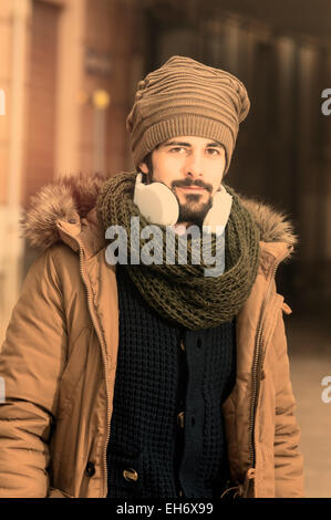 ein junger Mann hört Musik in einem städtischen Bild des modernen Lebensstils Instagram getönt Stockfoto