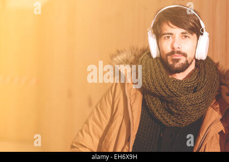 ein junger Mann hört Musik in einem städtischen Bild des modernen Lebensstils Instagram getönt Stockfoto