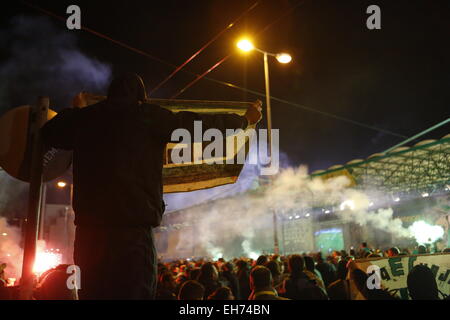 Athen, Griechenland. 8. März 2015. Ein Anhänger von Panathinaikos hält einen Banner und Uhren die Fans feiern. Fans der griechischen Fußball-Club Panathinaikos F.C. beobachten das Spiel gegen PAOK FC von Thessaloniki vor dem leeren Stadion. Alle Spiele der aktuellen Runde von der griechischen Superleague werden in leere Stadien gespielt, nachdem die Liga nach Unruhen ausgesetzt wurde. Bildnachweis: Michael Debets/Alamy Live-Nachrichten Stockfoto