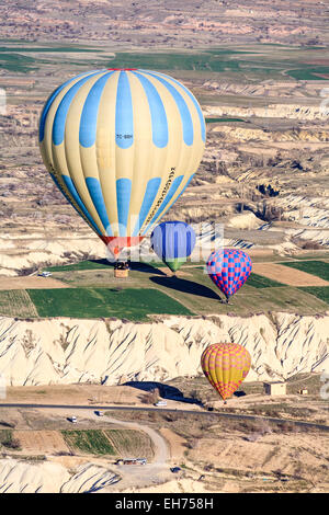 Touristische Sehenswürdigkeiten: Mehrere am frühen Morgen bunte Heißluftballons im Flug über dem Fairy Chimney Landschaft von Göreme in Kappadokien, Türkei steigen Stockfoto