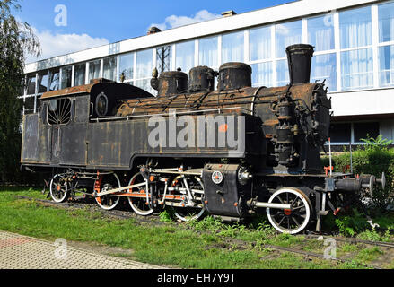 Alte Lok neben dem Gebäude des Bahnhofs Stockfoto