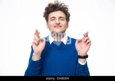 Junger Mann mit gekreuzten Fingern auf weißem Hintergrund Stockfoto