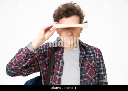 Junger Mann für seine Augen mit Buch über grauen Hintergrund Stockfoto