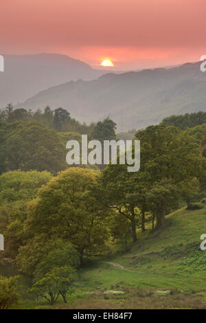 Sonnenuntergang über der Langdale Pikes gesehen von Loughrigg Tarn in der Nähe von Great Langdale, Lake District, Cumbria, UK Stockfoto