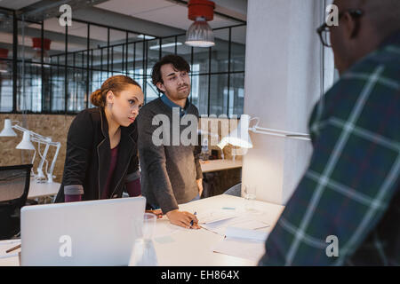 Geschäftsleuten stehen neben einer Tabelle arbeitet an neuen kreativen Ideen. Vielfältigen Team von young Professionals bei einem Treffen im Büro Stockfoto