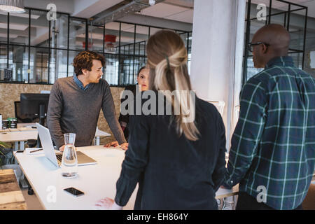 Team von jungen Designern zusammen im Büro arbeiten. Vielfältigen Business executive stehend an einem Tisch arbeiten an neuen Geschäft proje Stockfoto