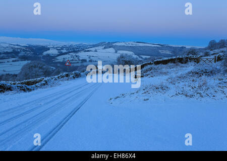 Neuschnee auf Feldweg, Winter vor der Morgendämmerung blaue Stunde, unter Curbar Rand, Peak District National Park, Derbyshire, England, UK Stockfoto