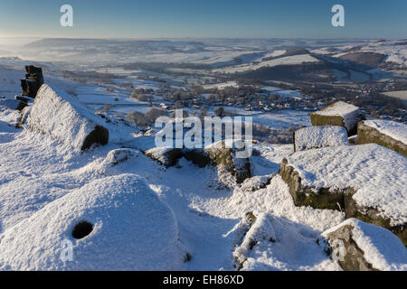 Neuschnee auf Mühlstein, Curbar Rand, nebligen Derwent Valley mit Curbar und Baslow Dörfer, Peak District, Derbyshire, England Stockfoto